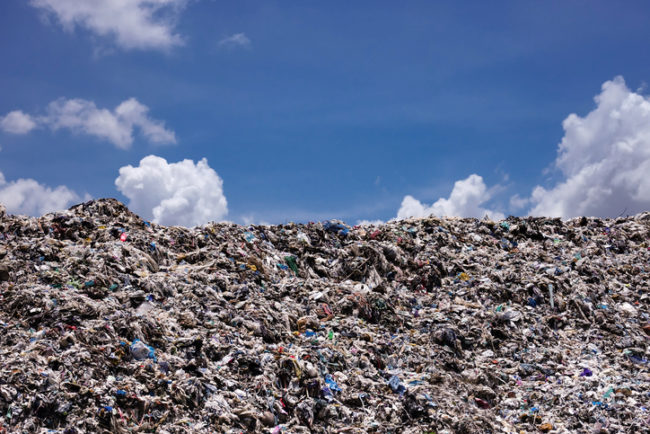 Landfill with blue sky and cumulus clouds