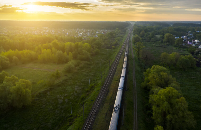 Freight train on the railroad at sunrise. Aerial view